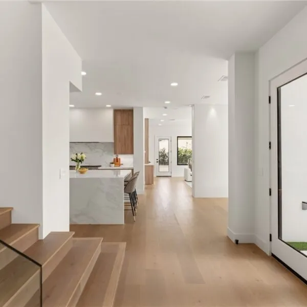 image of hallway going to kitchen with stairs and big glass door