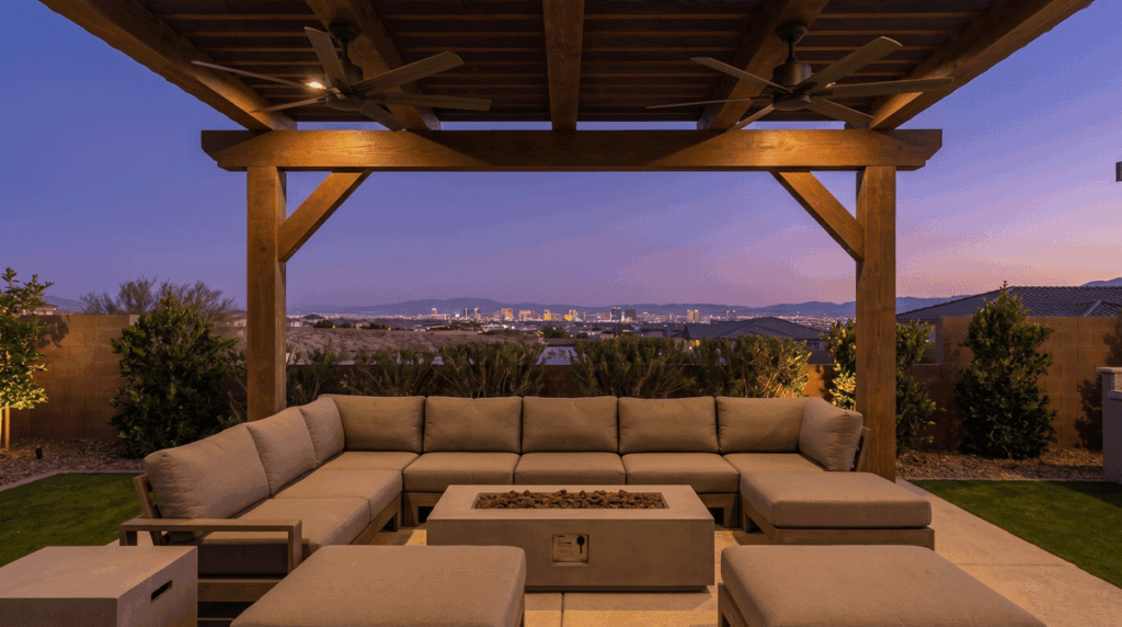 Shaded outdoor lounge area beneath a solid wood-beam ramada with ceiling fans